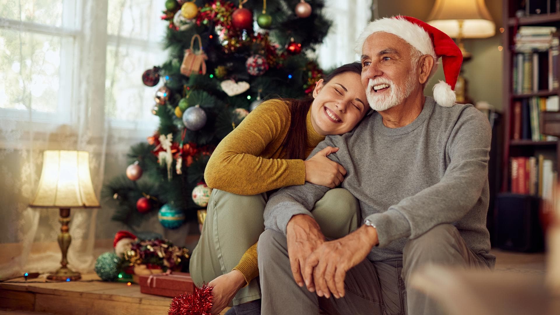 Tochter mit Vater vor Weihnachtsbaum