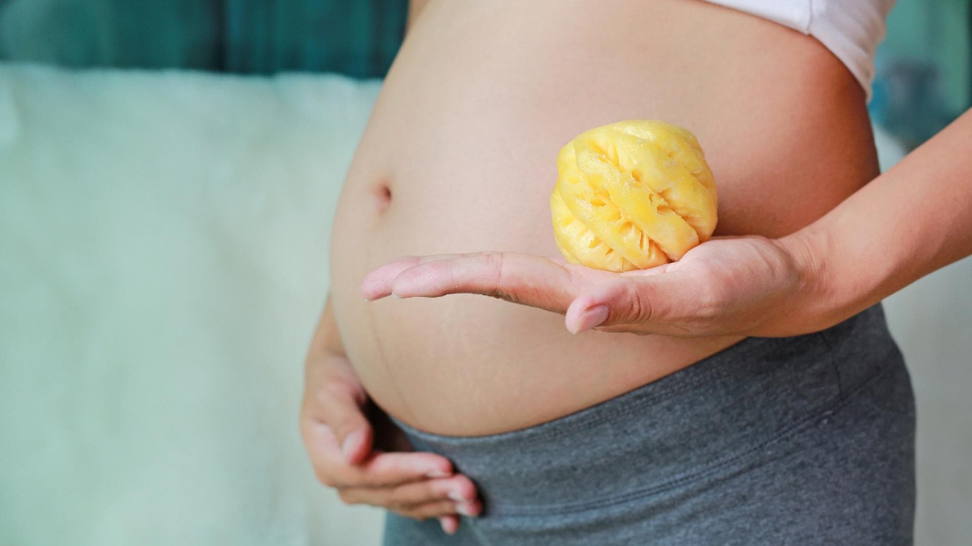 Schwangerer Bauch und Ananas