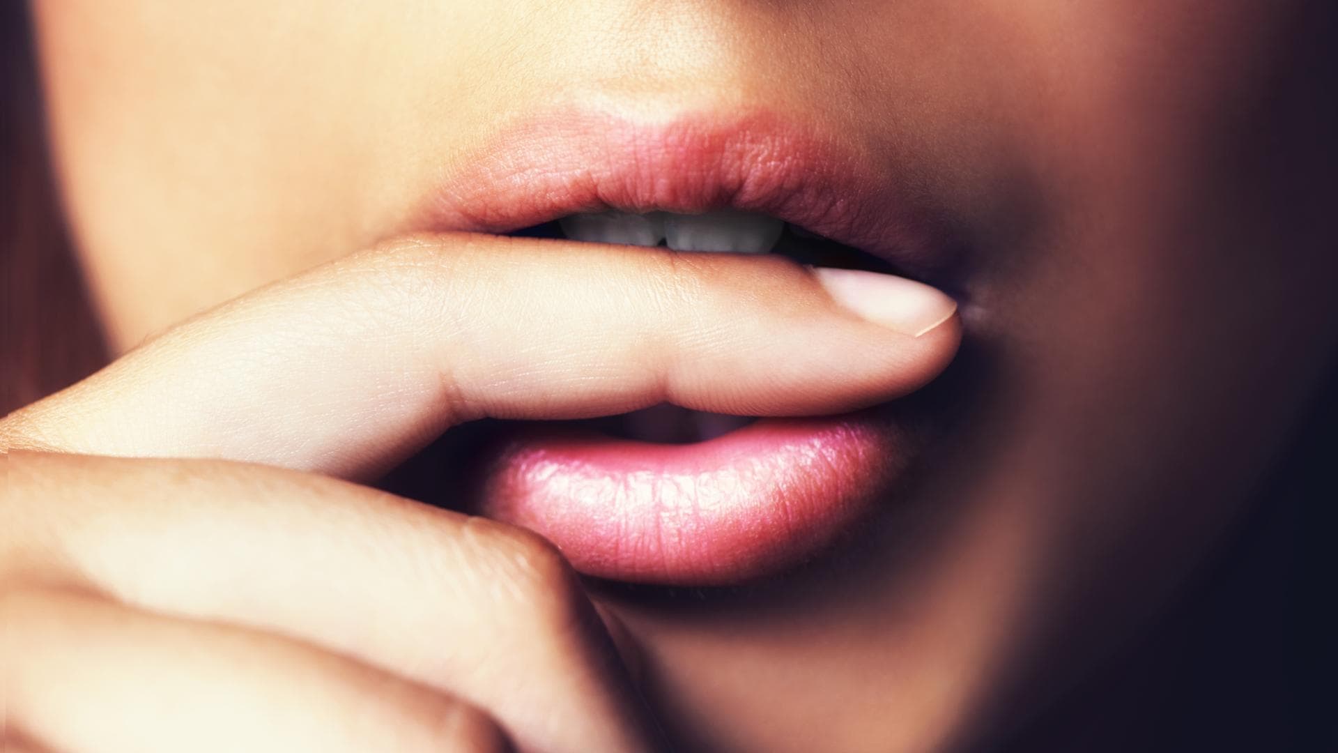 Frau beißt sich auf Finger