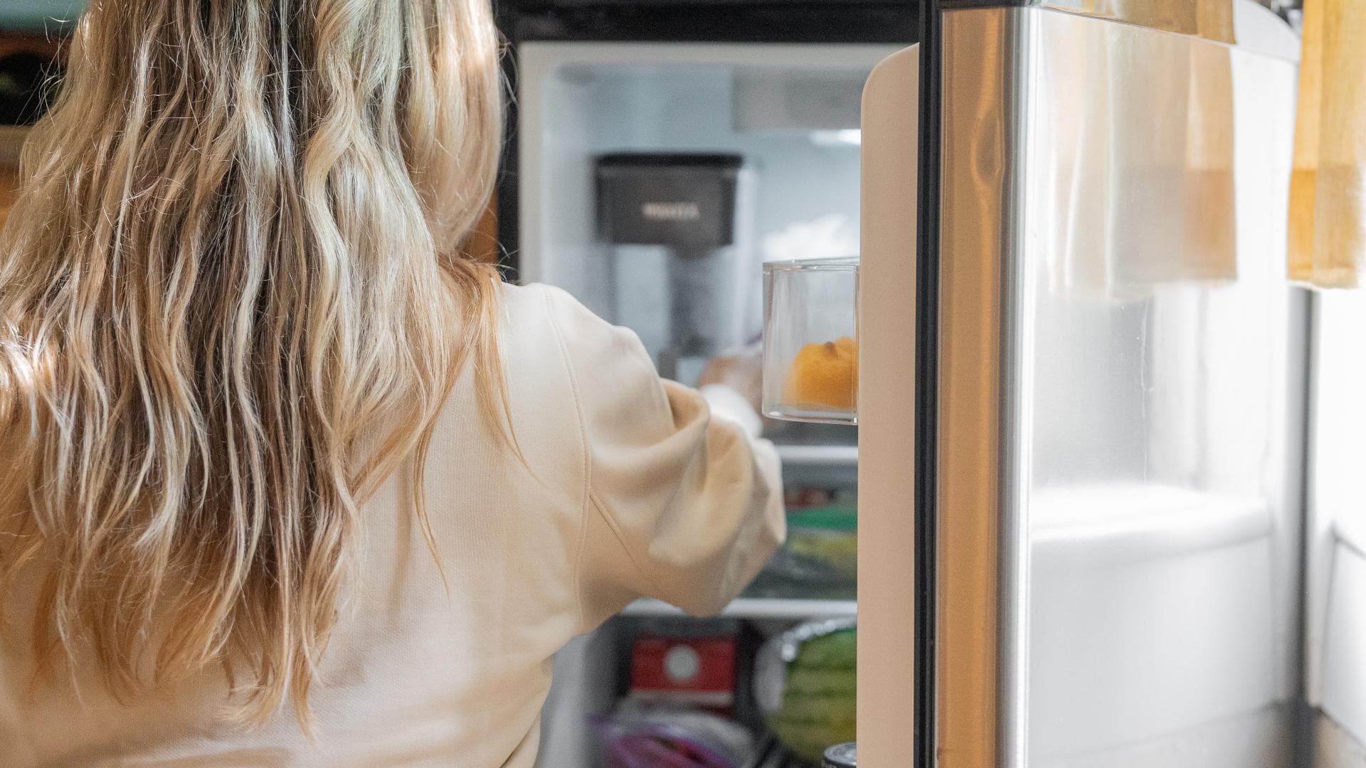 Frau vor dem Kühlschrank