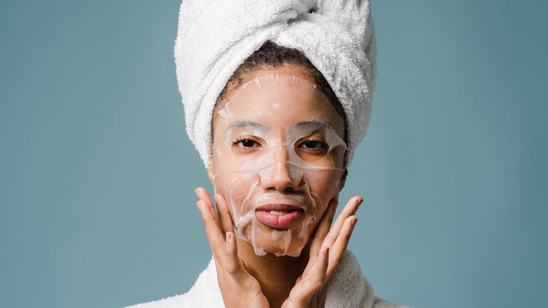 Frau im Bademantel mit Gesichtsmaske