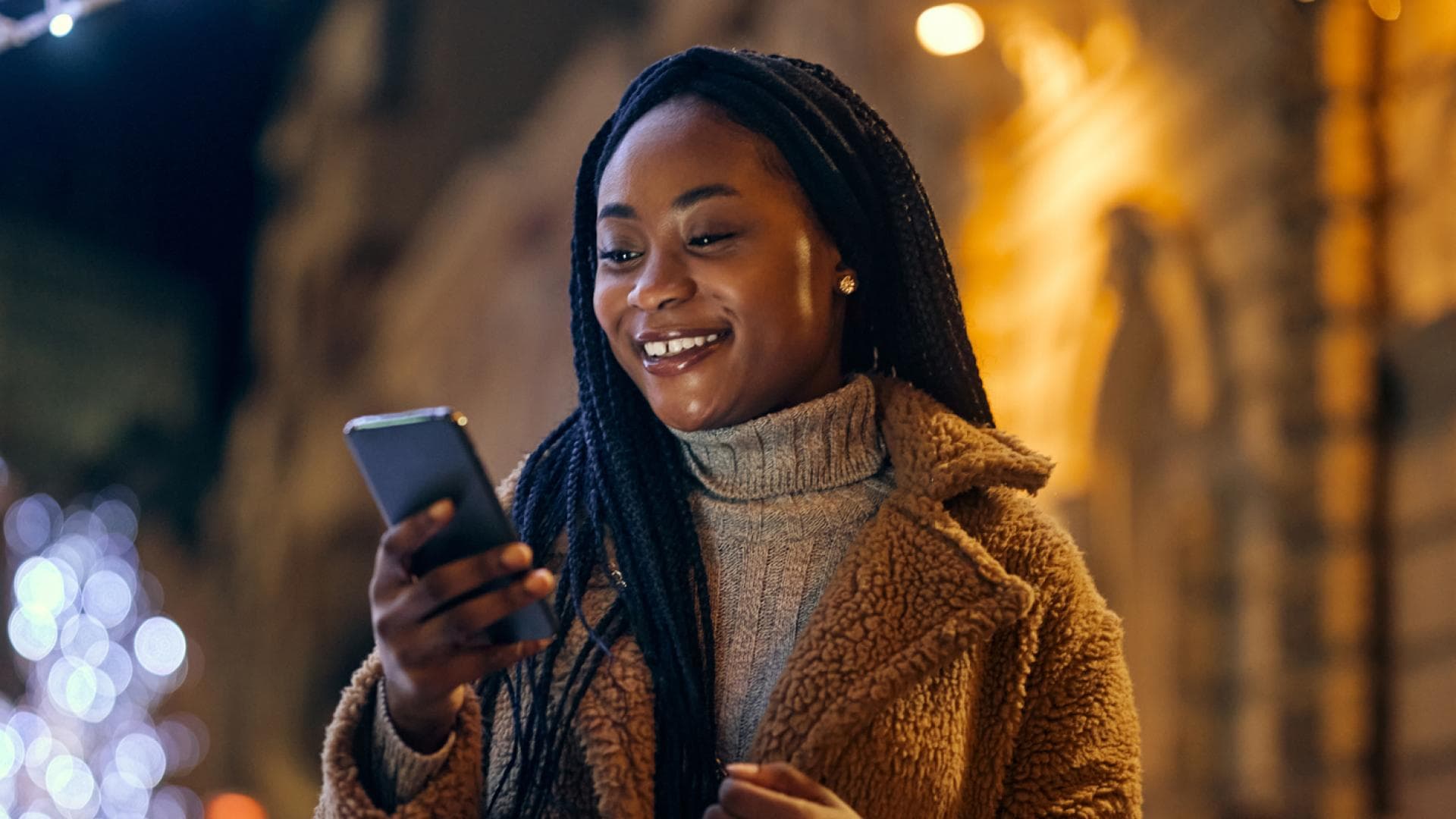 Frau schaut erfreut aufs Handy