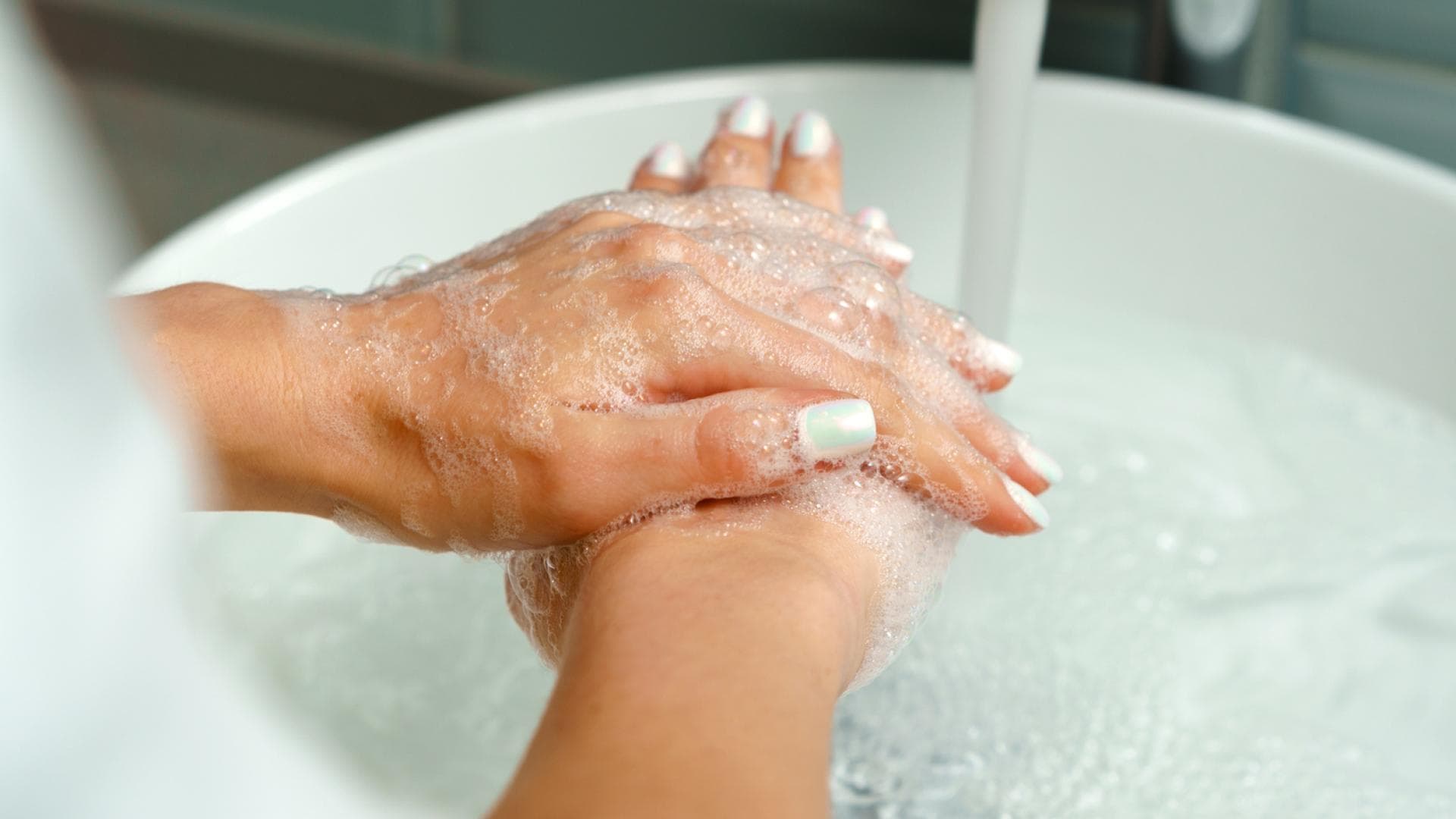 Frau hält Hände unter Wasser