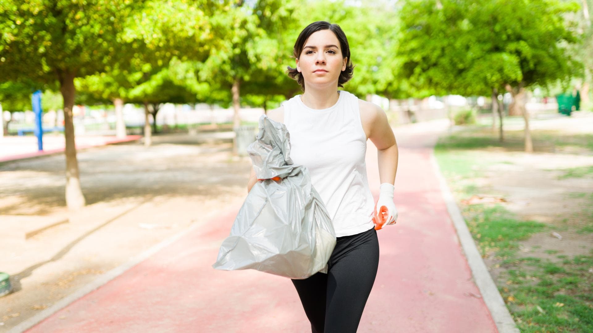 Frau läuft mit Mülltüte