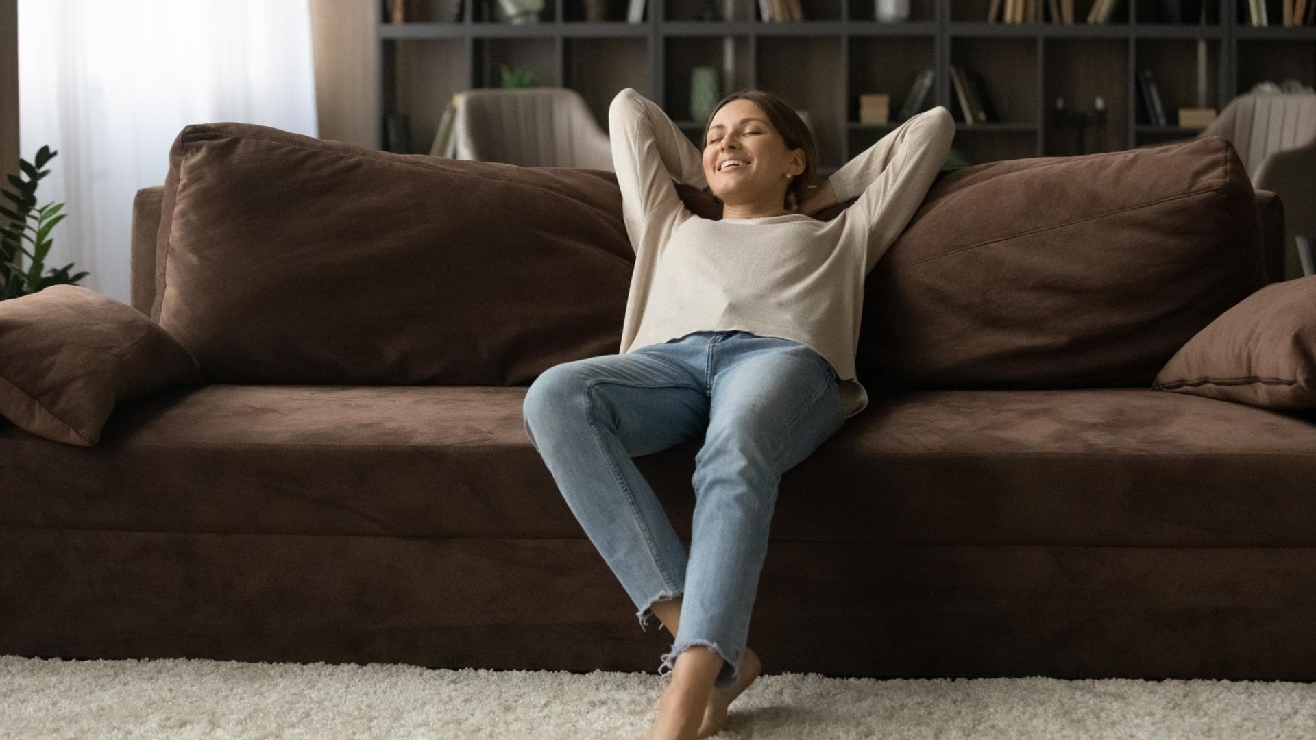 Junge Frau auf Sofa in kleiner Wohnung