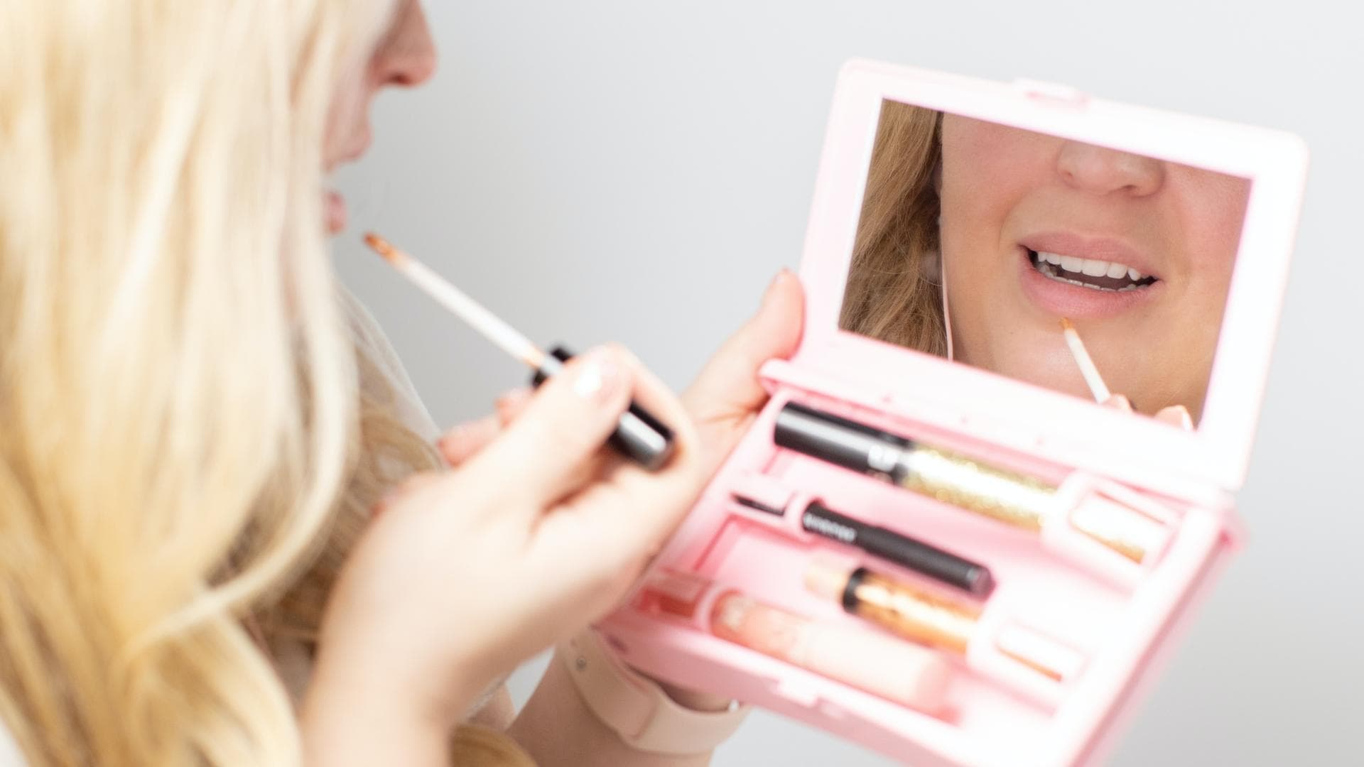 Frau trägt Lipgloss auf