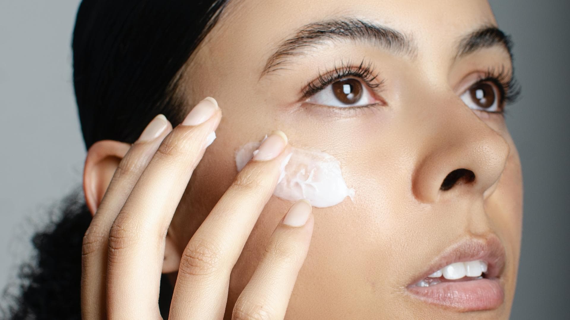 Frau trägt Gesichtscreme auf