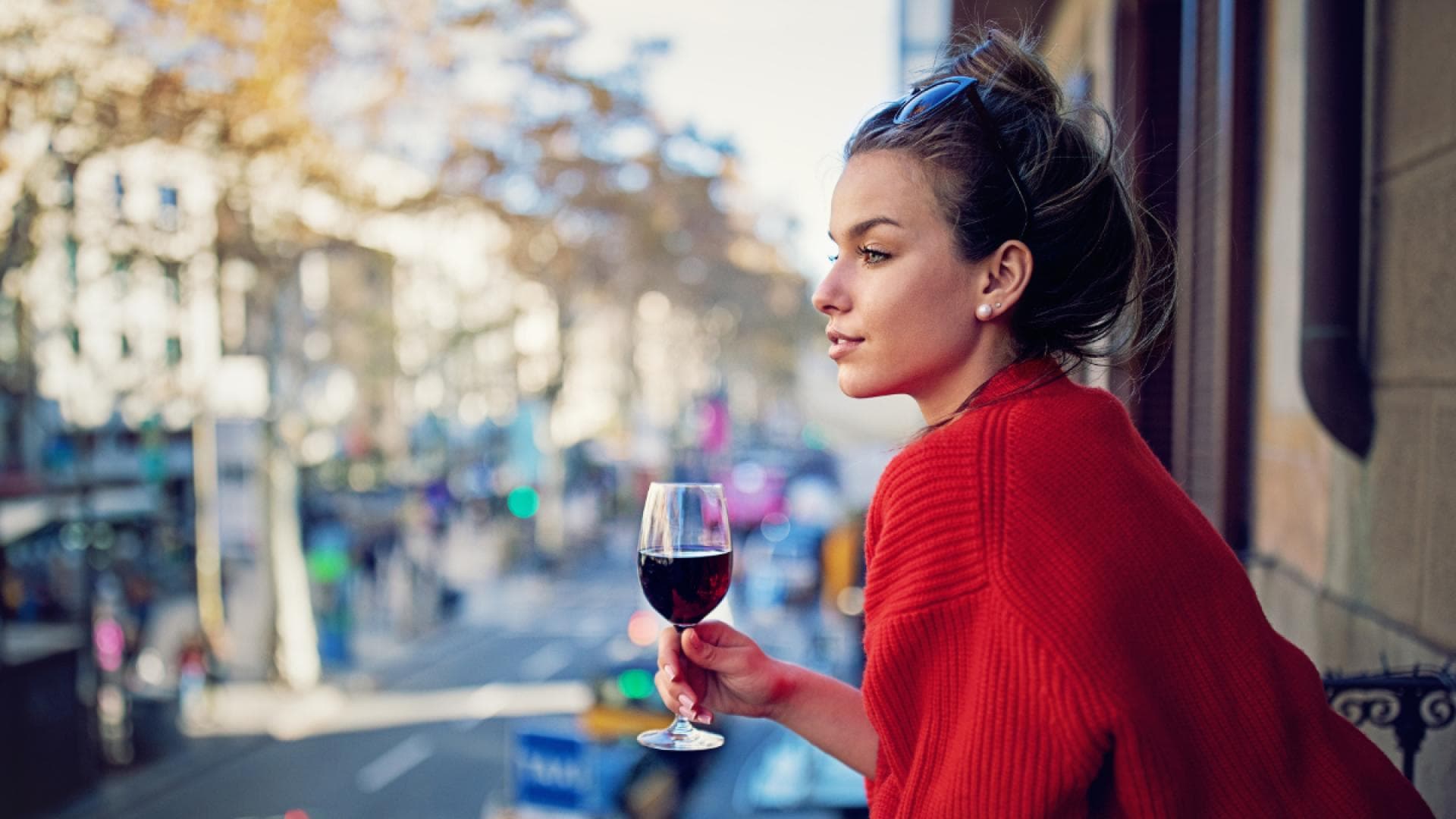 Frau mit Wein auf Balkon