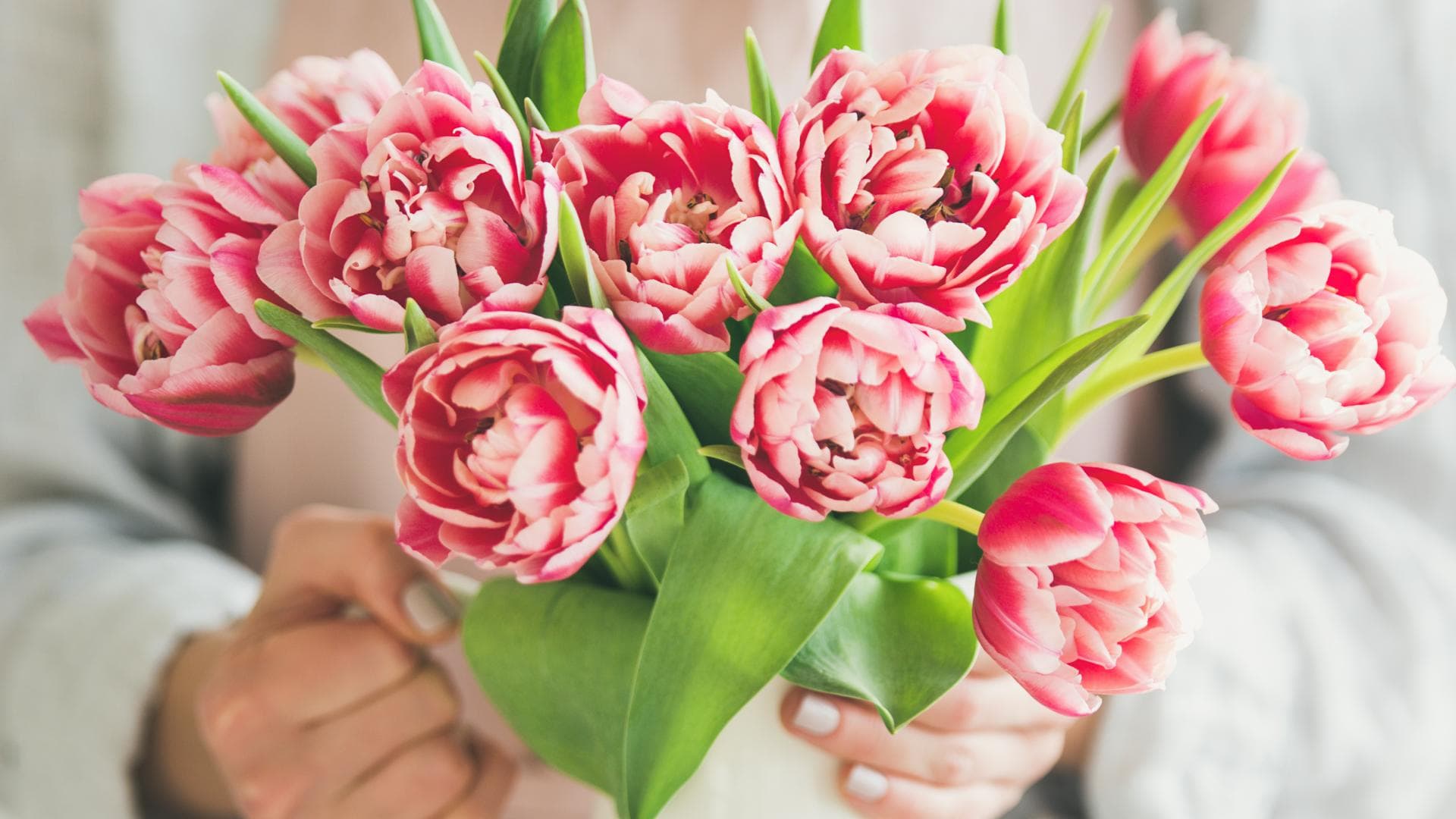 Frau drappiert Blumen in Vase