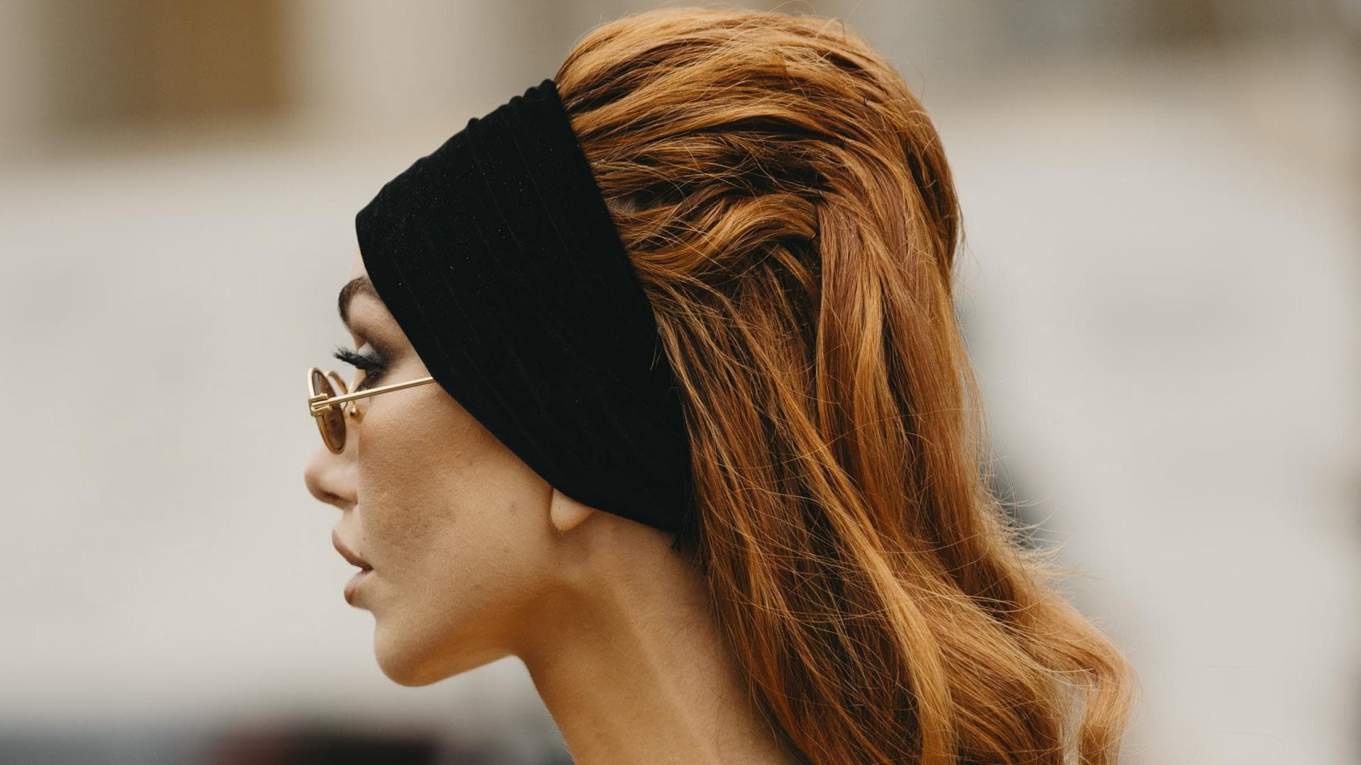 Frau auf Paris Haute Couture Fashion Week trägt schwarzes Kleid rote Haare Haarband Streetstyle