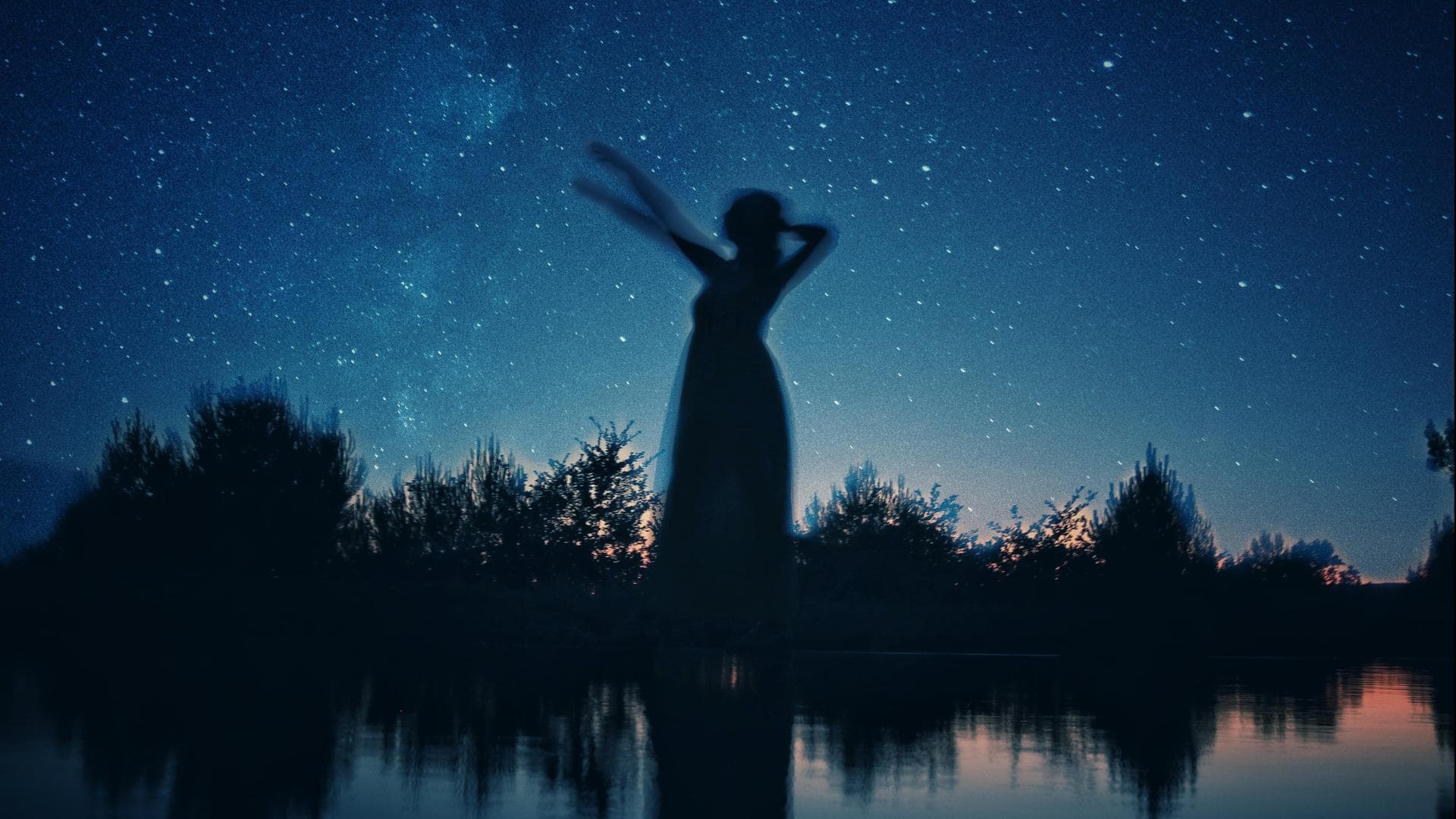 Schattenbild einer Frau an einem See in der Nacht
