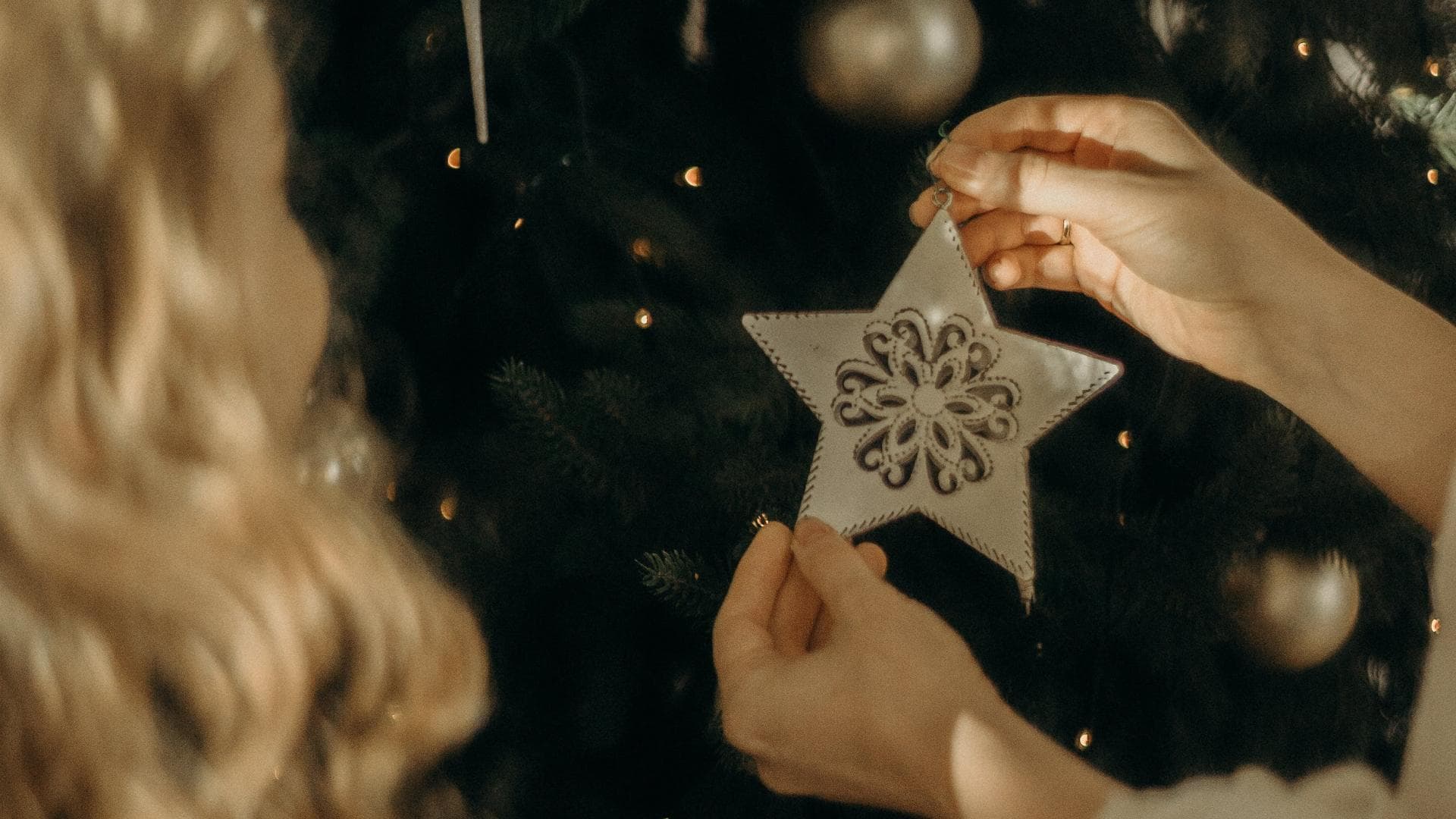 Frauen schmücken Weihnachtsbaum mit Stern