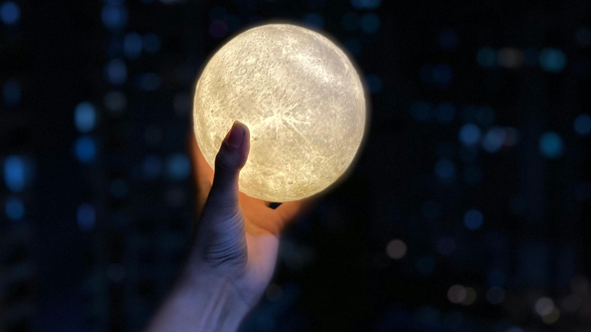 Hand hält eine Lichterkugel