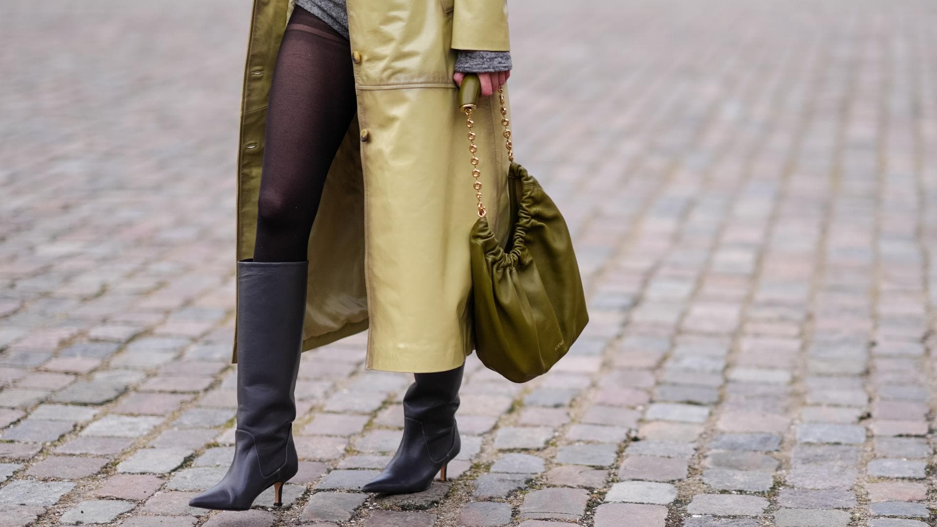 Kniehohe Stiefel kombinieren Frau trägt Stiefel in Grau mit Kitten Heel und spitzer Zehenpartie Ledermantel und Strumpfhose