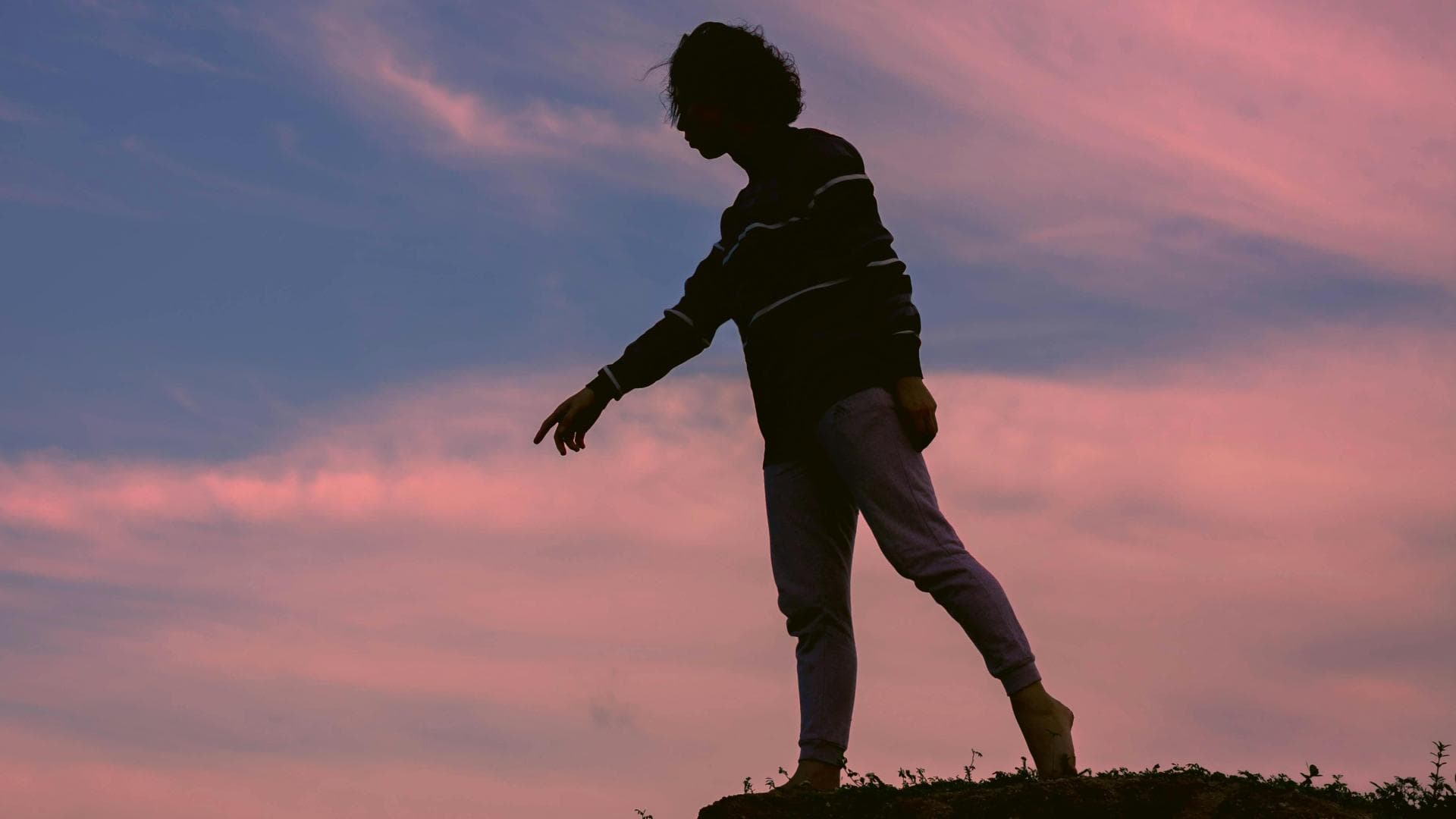 Silhouette einer Frau vor einem rosafarbenen Himmel