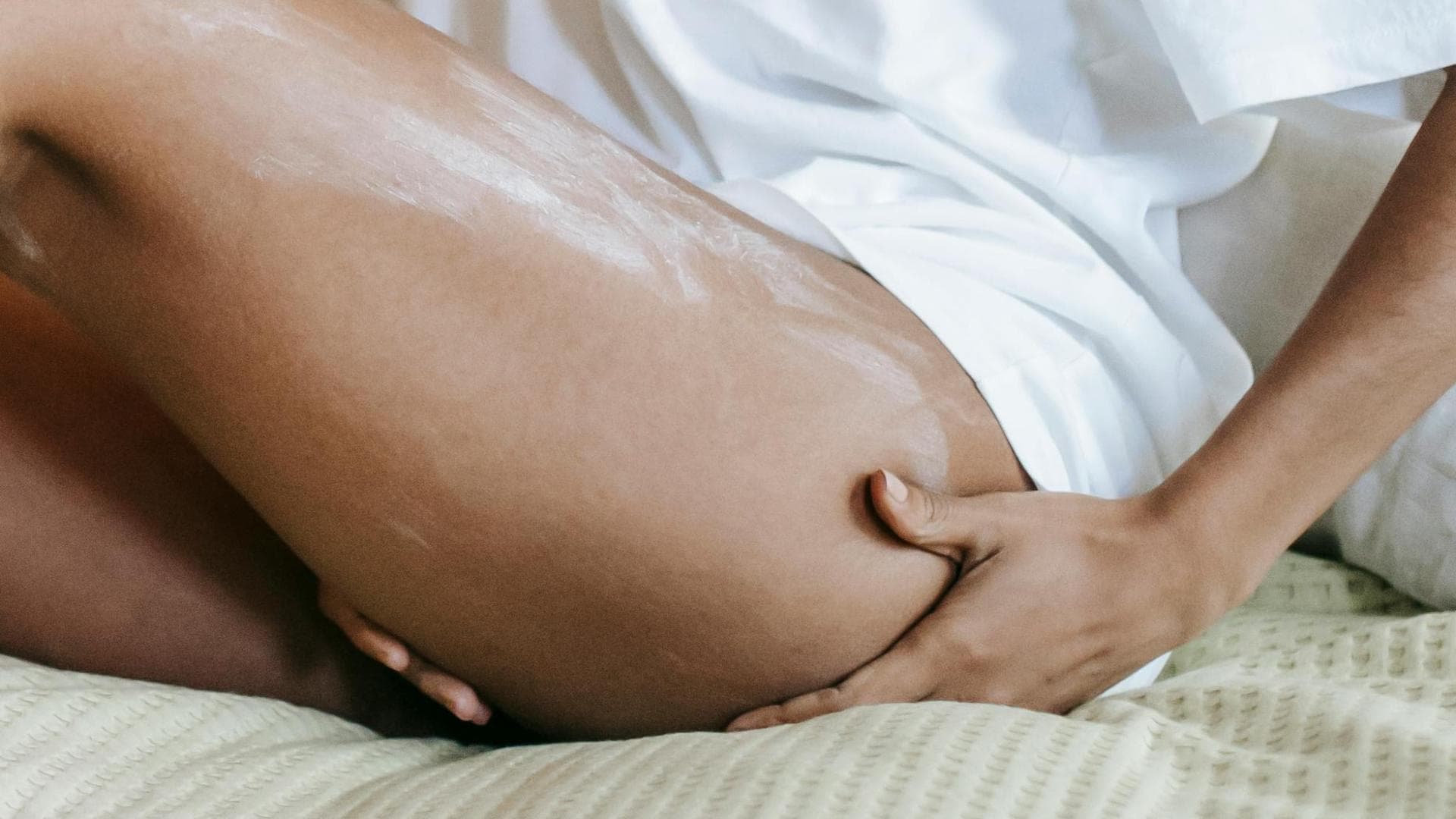 Frau trägt Bodylotion auf