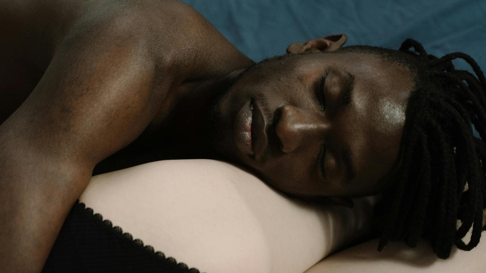 Mann liegt auf Beinen von Frau