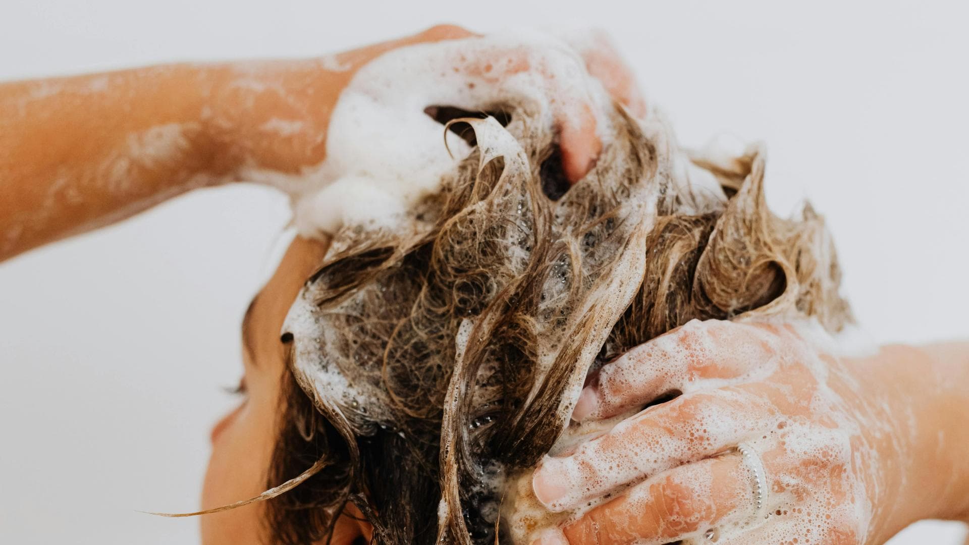 Frau shampooniert ihre Haare