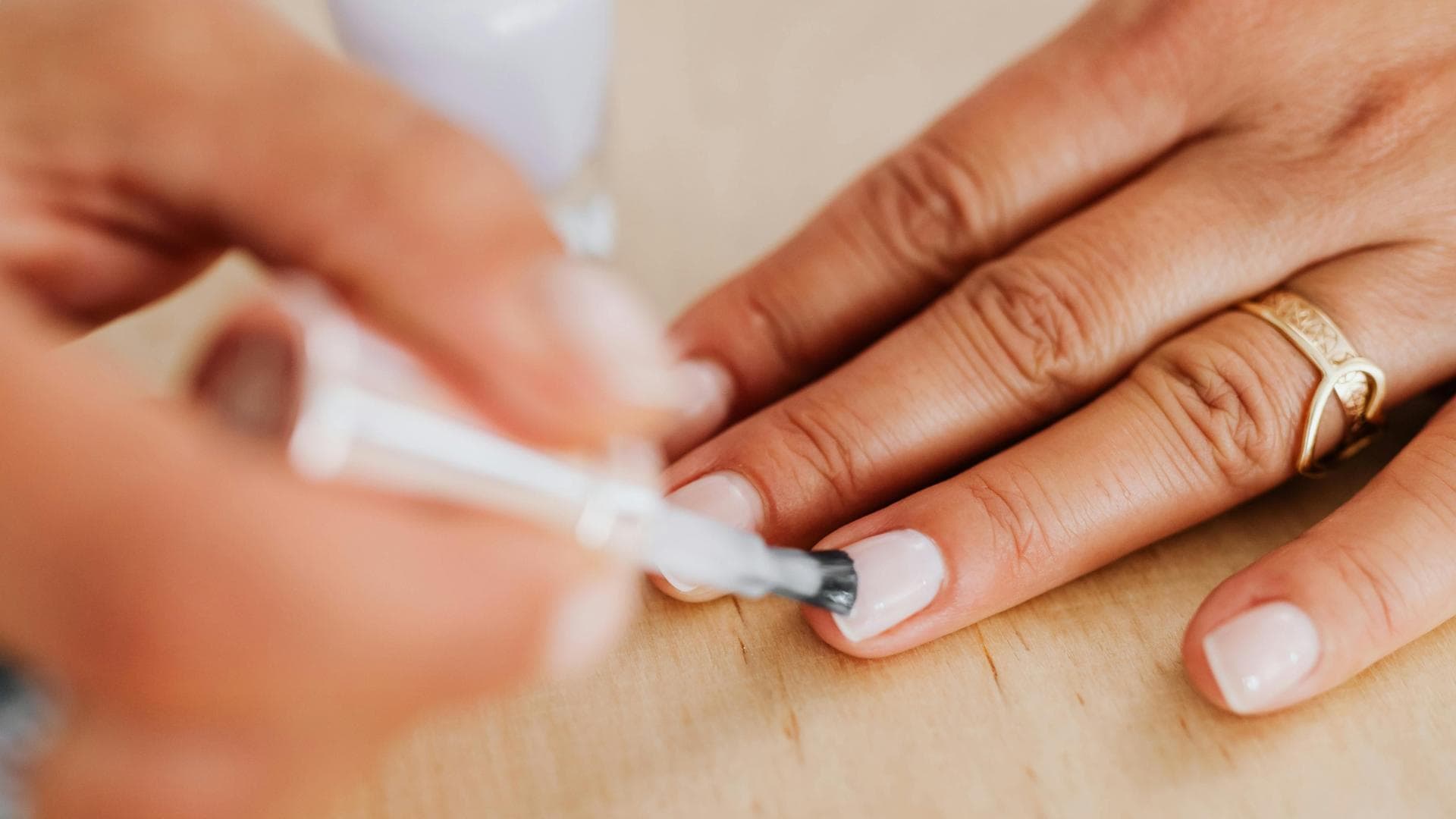 Frau trägt weißen Nagellack auf