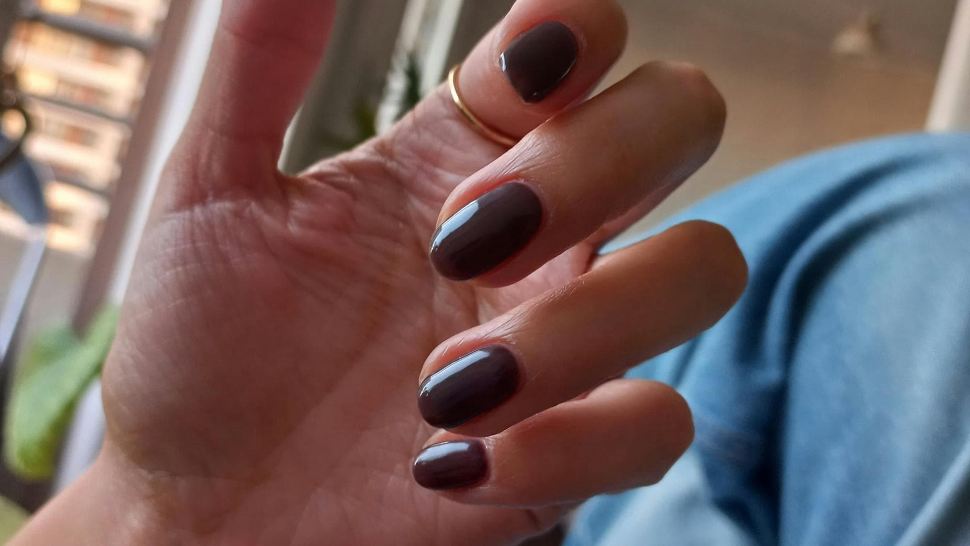 Nägel mit dunkelbrauner Farbe lackiert