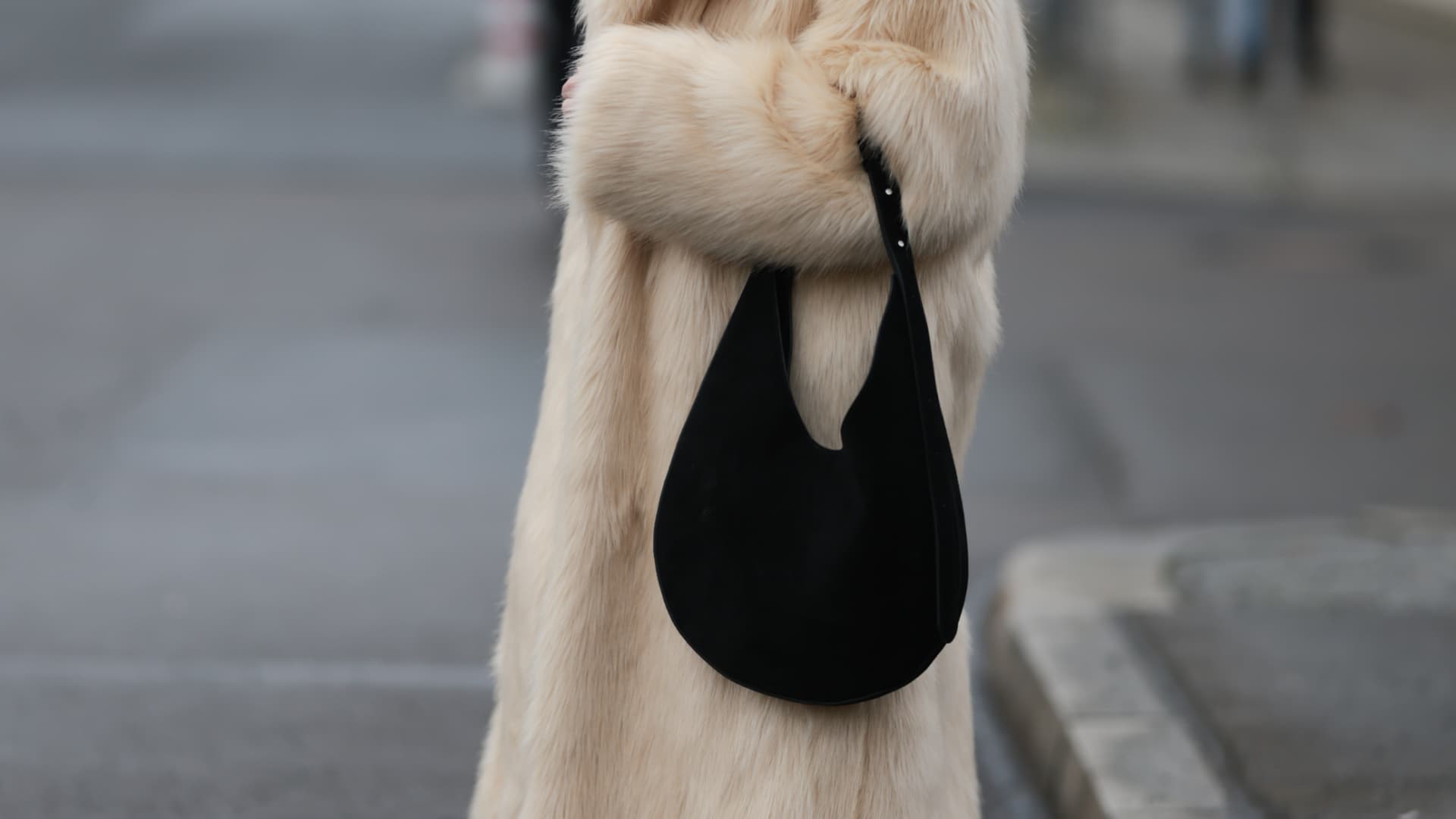 Frau in dickem Fellmantel mit großer Slouchy Bag