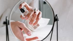 Frau sprüht Parfum auf