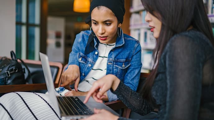 Zwei Frauen schauen auf ihren Laptop