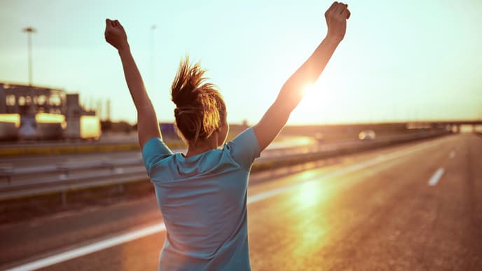 Horoskop Thema: Frau läuft mit erhobenen Händen