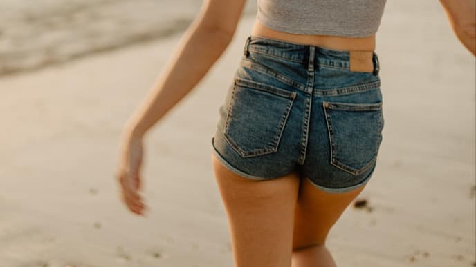 Mädchen mit Jeansshorts am Strand 