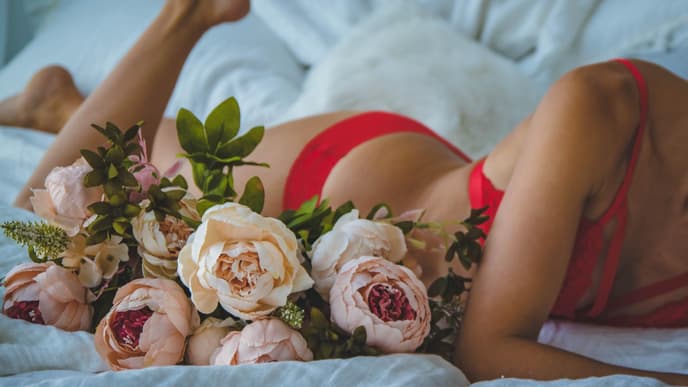 frau im bett in unterwäsche mit blumen