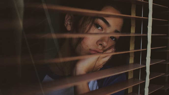 Frau guckt durch Fenster