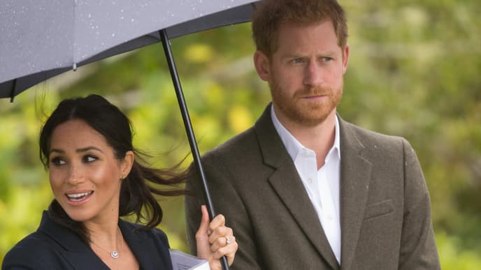 Meghan Markle hält den Regenschirm für Prinz Harry