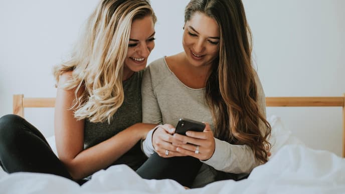 Zwei Frauen gucken auf ihr Handy