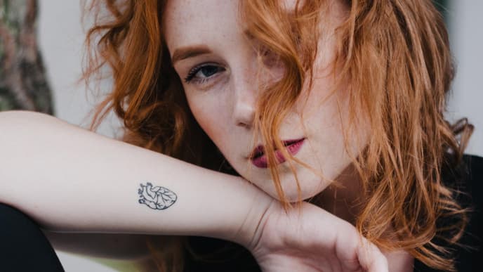 Frau mit Tattoo am handgelenk