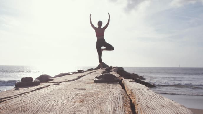 Frau macht Yoga auf Steg