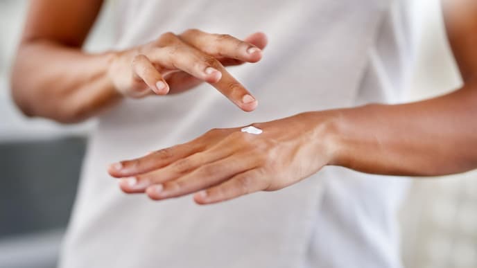frau mit handcreme cremt hände ein