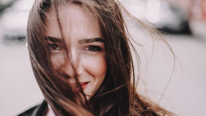 Junge Frau mit reiner Haut und wehenden Haaren 