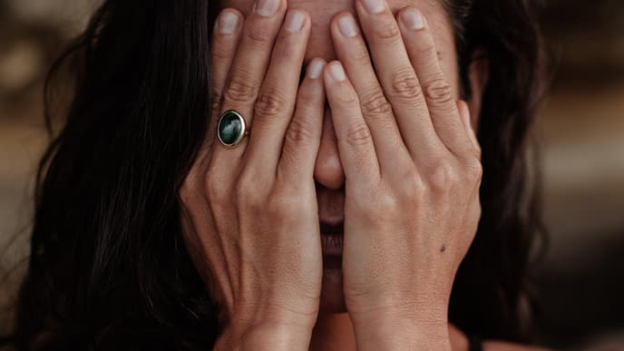 Frau hält sich Hände vor das Gesicht