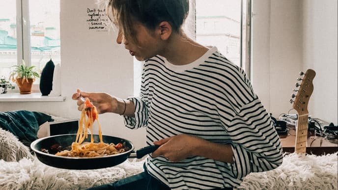 Frau mit Spaghetti in einer Pfanne