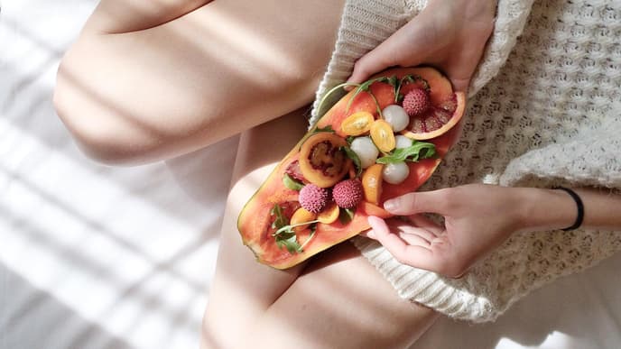Frau mit Papaya im Bett