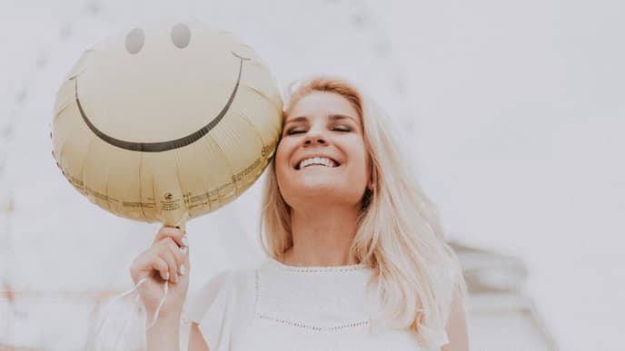 Frau lacht mit Ballon