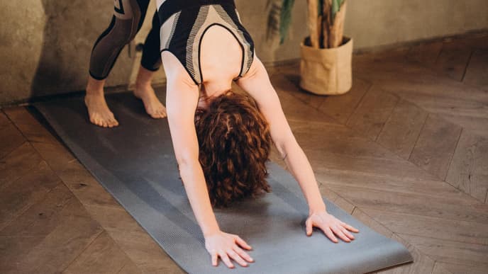 Frau beim Yoga im Herabschauenden Hund