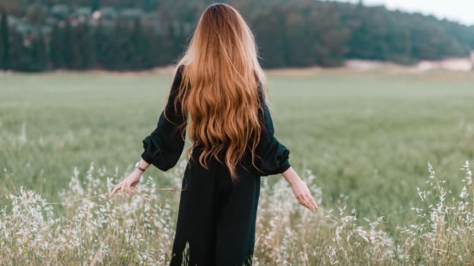 Frau mit langen Haaren auf einer Wiese
