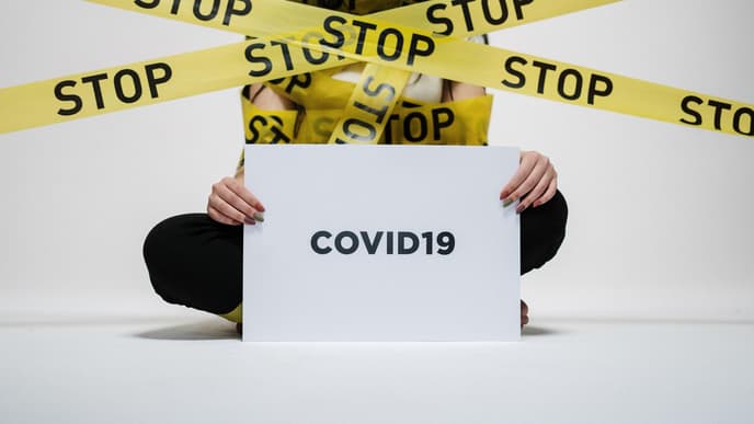 Mensch mit Corona Schild