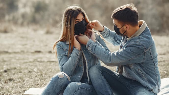Frau und Mann mit Atemmaske in der Natur