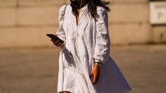 Frau im Sommerkleid mit Mund-Nasen-Schutzmaske