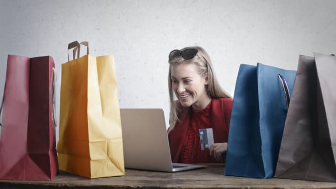 Frau vor Laptop neben Tüten