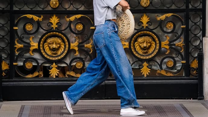Frau trägt weite Jeanshose und Chucks