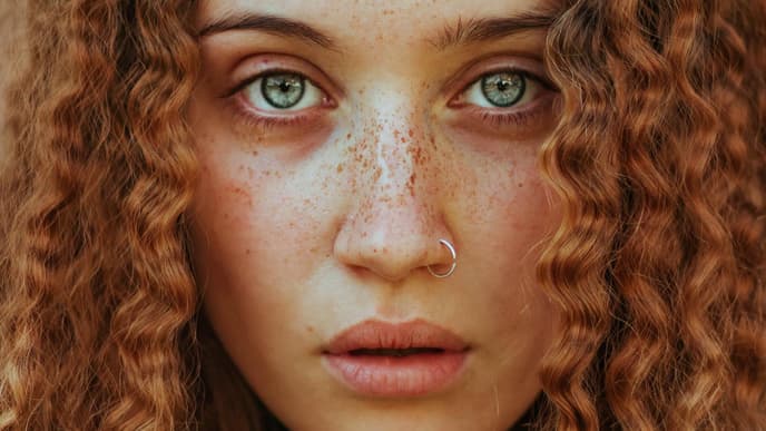 Frau mit roten Locken und Piercing