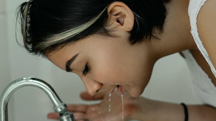Mädchen wäscht sich im Waschbecken ihr Gesicht